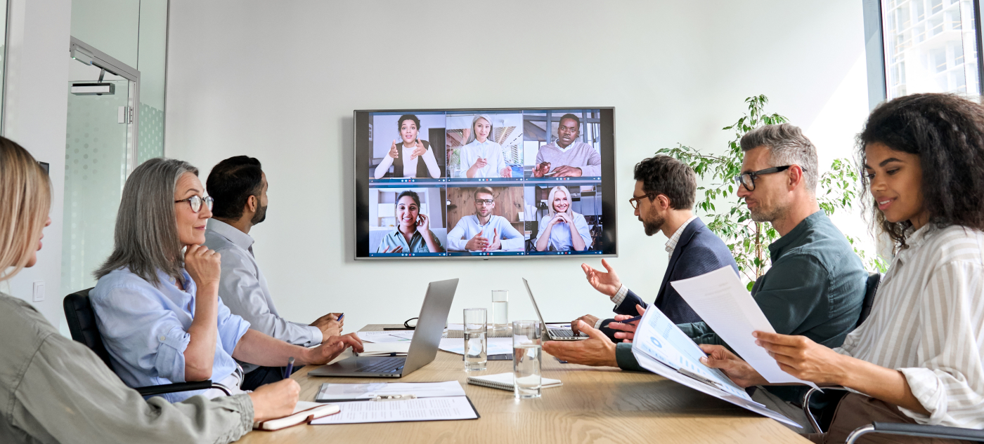 A group of people participate in a hybrid meeting.