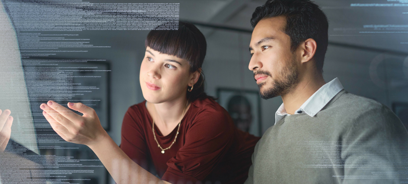 Two researchers look at data on a computer.