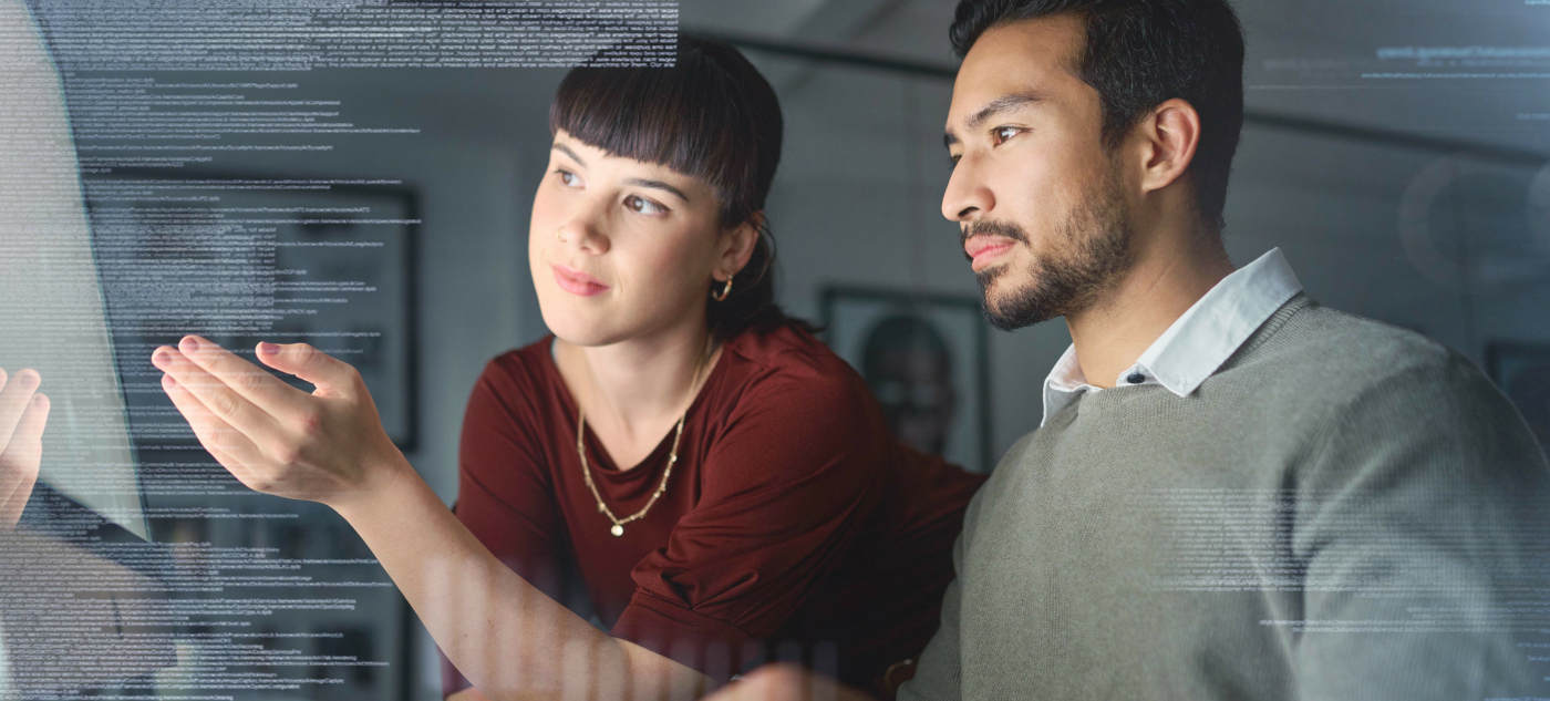 Two researchers look at data on a computer.